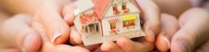 Family holding house in hands. Real estate concept