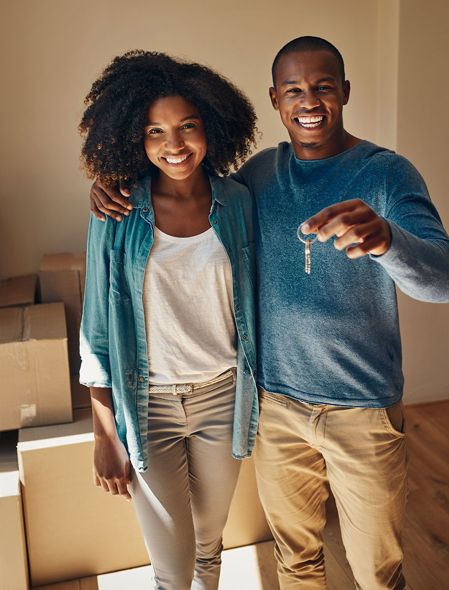 New homeowners with keys and moving boxes