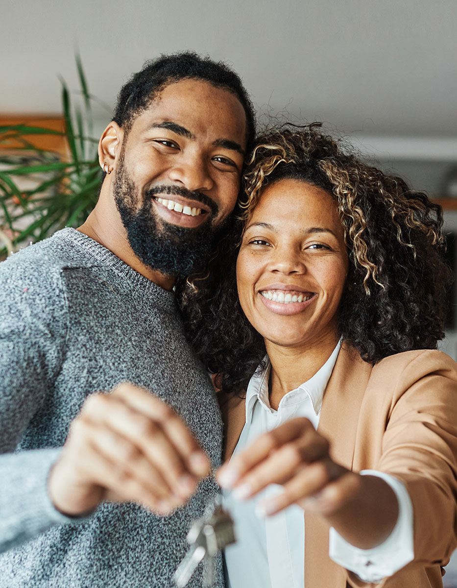 happy couple holding the keys to their new house