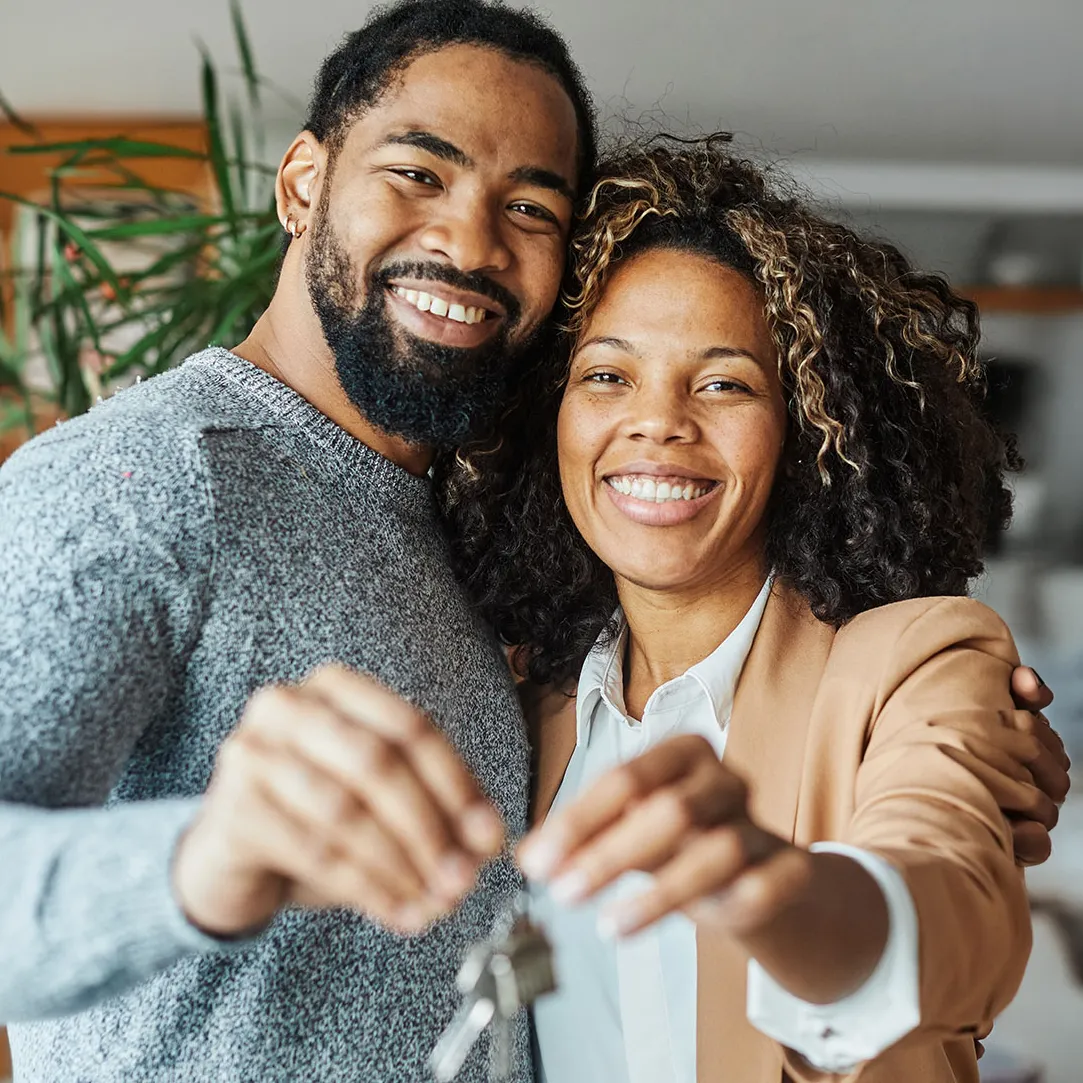 happy couple holding the keys to their new house